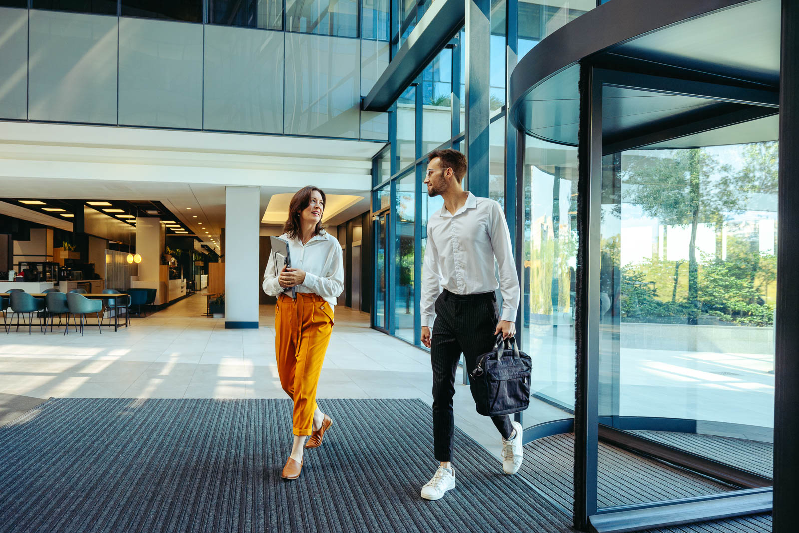 Coworkers arriving at modern office building entrance
